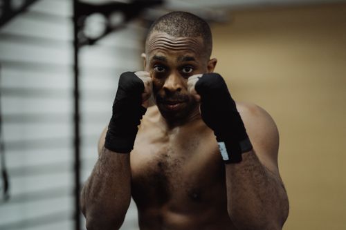 Free Topless male boxer in a fighting stance with wrapped hands, ready for action. Stock Photo