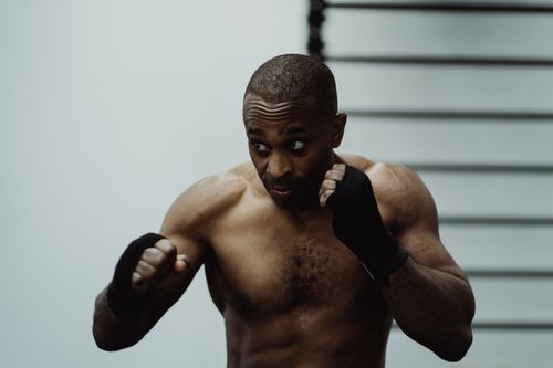 Free A muscular African American boxer trains intensely indoors, showcasing strength and focus. Stock Photo