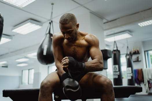 Dedicated boxer preparing with gloves in a gym, showcasing strength and focus during training.