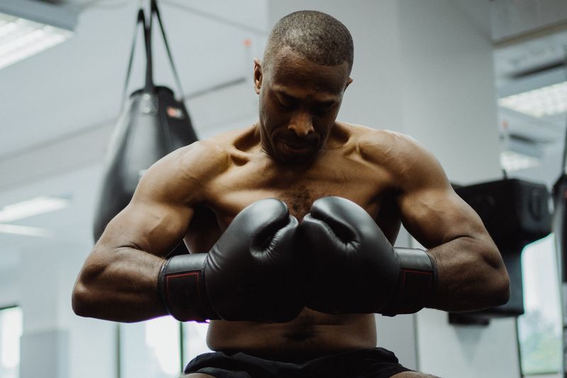 Coach portrait examining boxing gloves