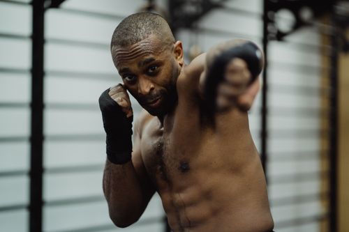 Free Determined boxer delivering a punch during training at the gym, showcasing strength and focus. Stock Photo
