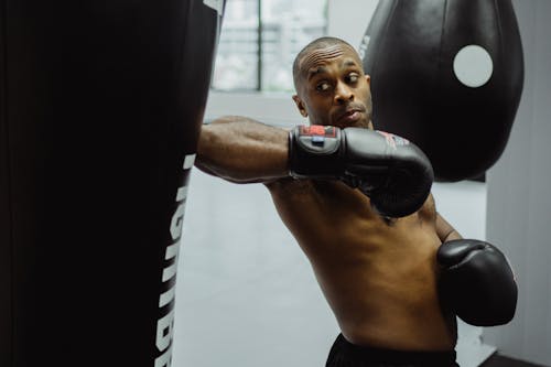 Man Wearing Black Boxing Gloves While Doing a Training