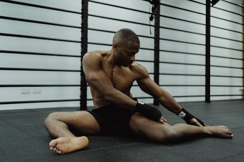 Free Man Sitting on the Floor Trying To Reach His Foot  Stock Photo