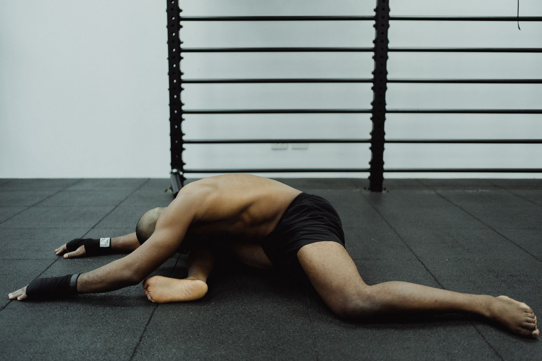 Athlete stretching on a mat, focusing on muscle recovery and flexibility.