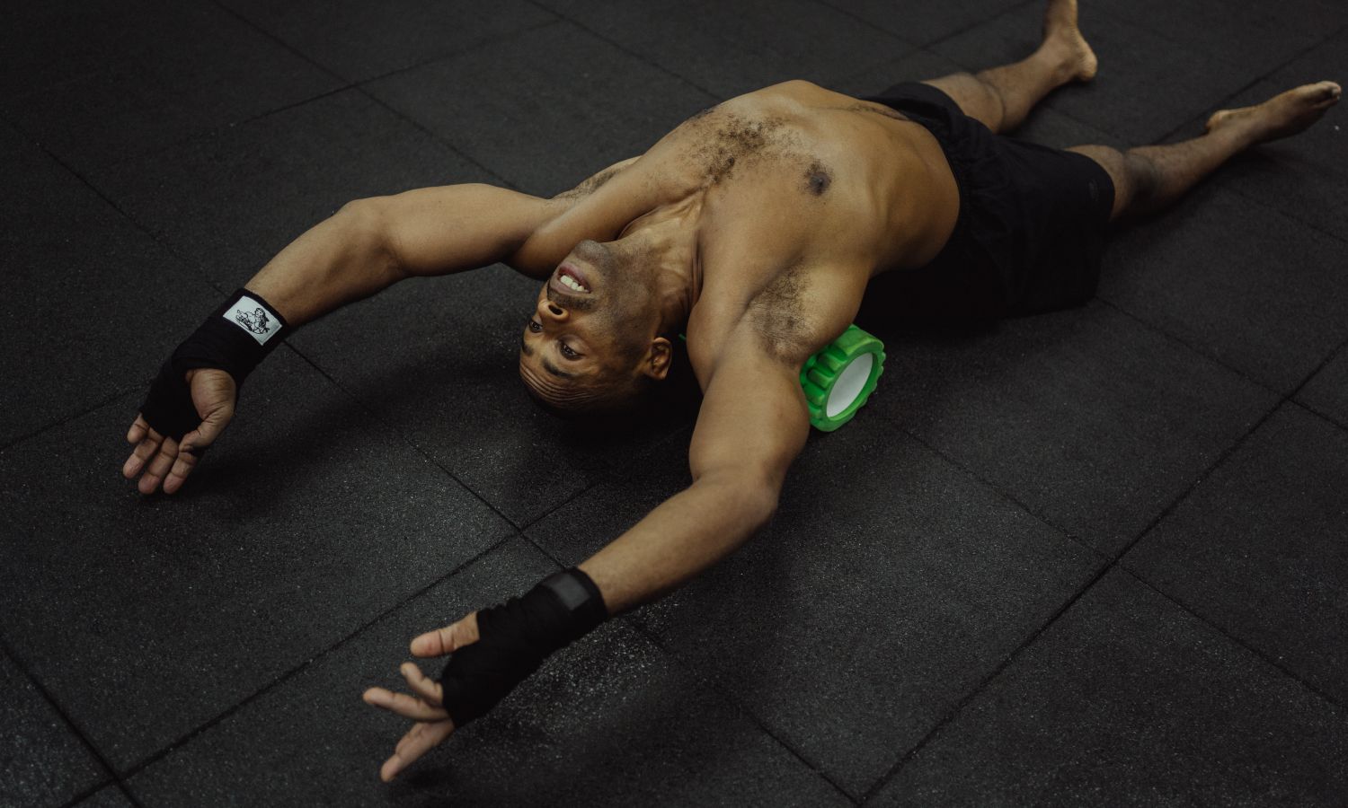 Hombre usando un rodillo de espuma para recuperación muscular tras el entrenamiento