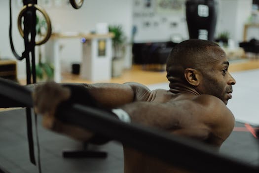 Fit adult man using resistance bands in a gym setting, focusing on strength and fitness.