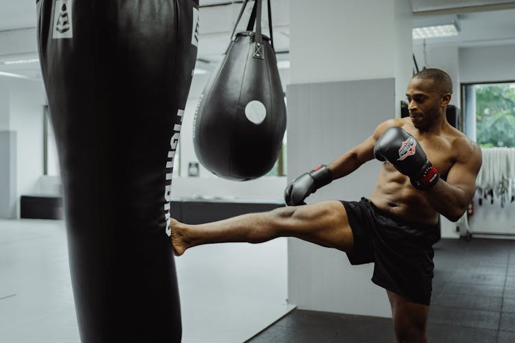 Man Kicking The Black Punching Bag