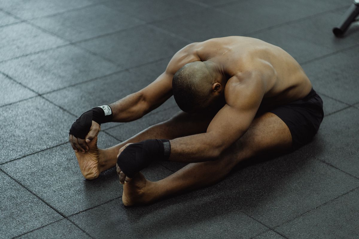 Man stretching on the floor during a recovery session after training