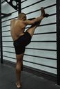 Man in Black Shorts Extending His Leg on Black Metal Bars