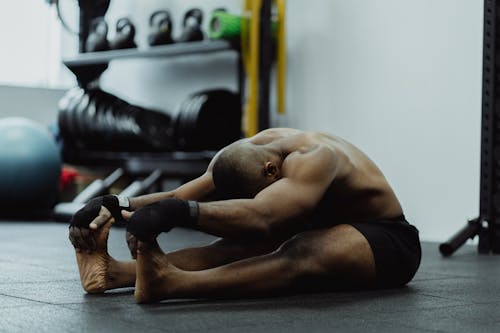 Free Man Sitting Stretching His Legs and Arms  Stock Photo