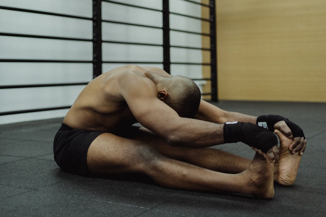 Free Topless Man Stretching His Legs and Arms  Stock Photo