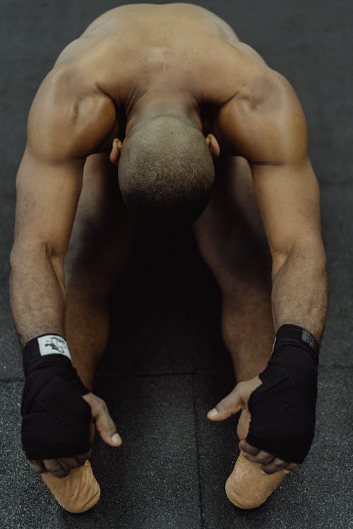 Free Man on the Floor Stretching His Legs and Arms  Stock Photo