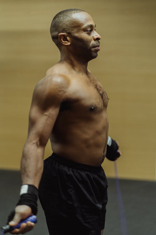 Man in Black Shorts Holding a Blue Jumping Rope 