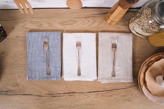 Striped linen napkins and forks laid on an oak table — photo by Tima Miroshnichenko on Pexels