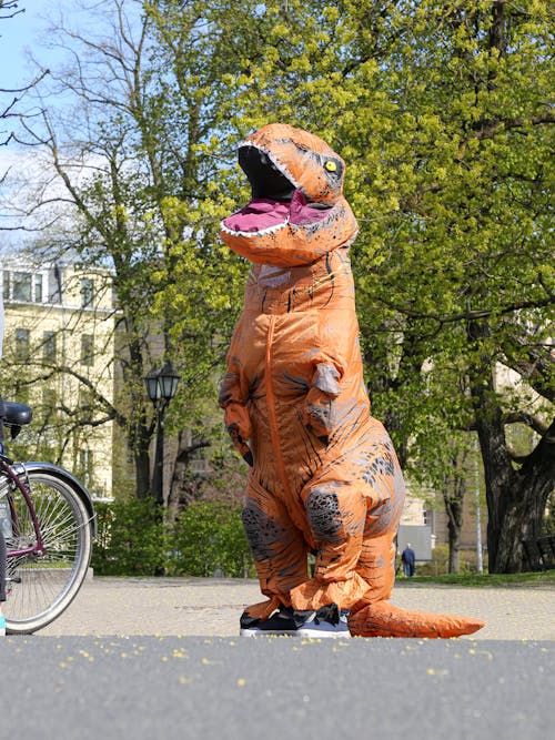 Faceless person in dinosaur costume standing on city street