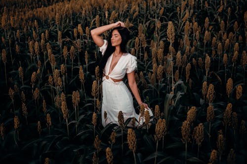 A Woman in White Dress Posing in a Sorghum Field