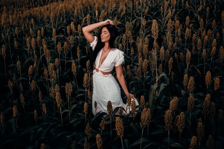 A Woman In White Dress Posing In A Sorghum Field