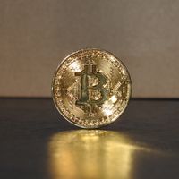 Golden coin standing upright on a reflective surface — photo by Ewan Kennedy on Pexels