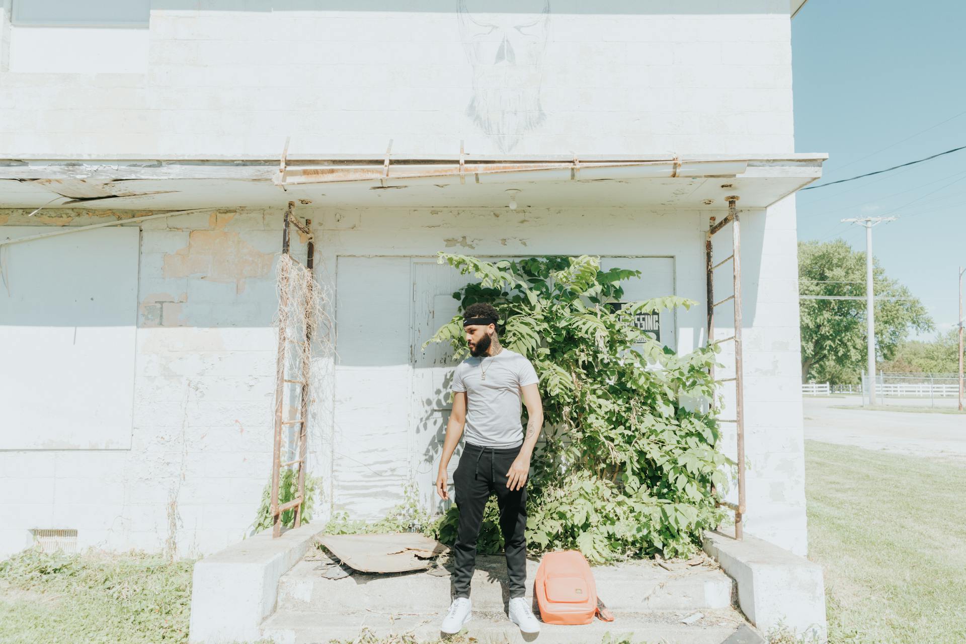 A man standing by an old building in Omaha, Nebraska on a sunny day.