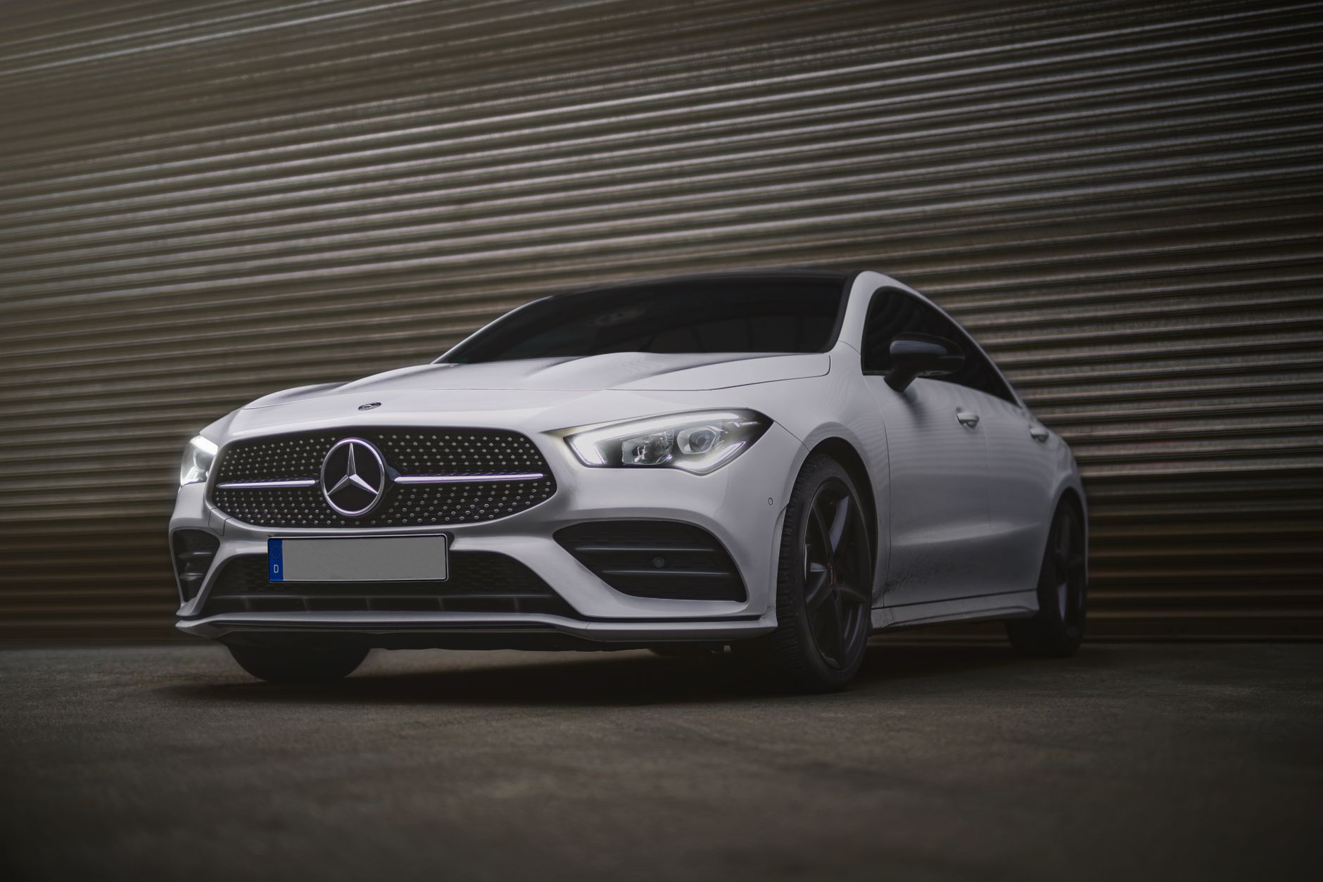 Low angle view of a sleek white Mercedes Benz sedan parked outdoors, exuding elegance and sophistication.