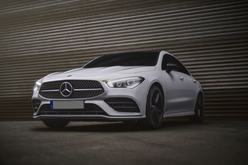 Free Low angle view of a sleek white Mercedes Benz sedan parked outdoors, exuding elegance and sophistication. Stock Photo