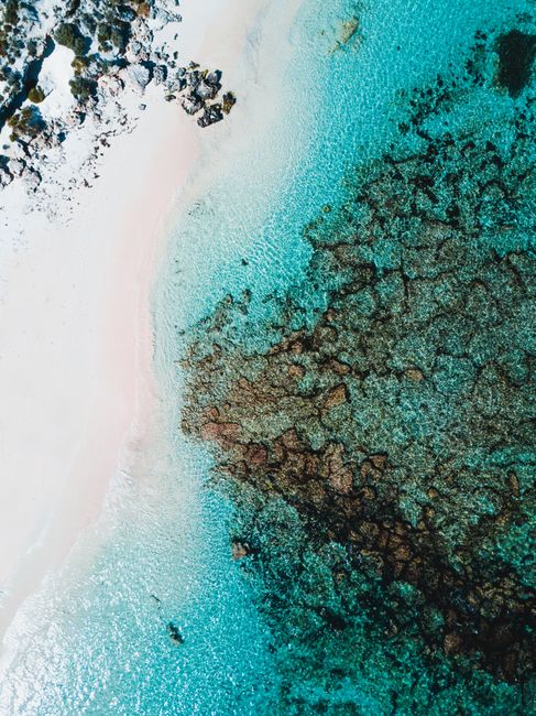 Stunning aerial shot of Rottnest Island's turquoise waters and white sandy beach.