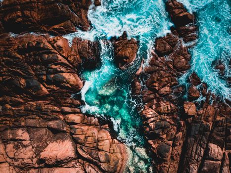 A stunning aerial view of waves crashing against the rocky coastline at Yallingup, Western Australia.