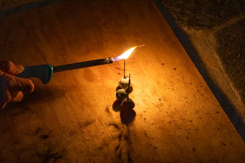 Foto profissional grátis de bombinha, chama, escuro