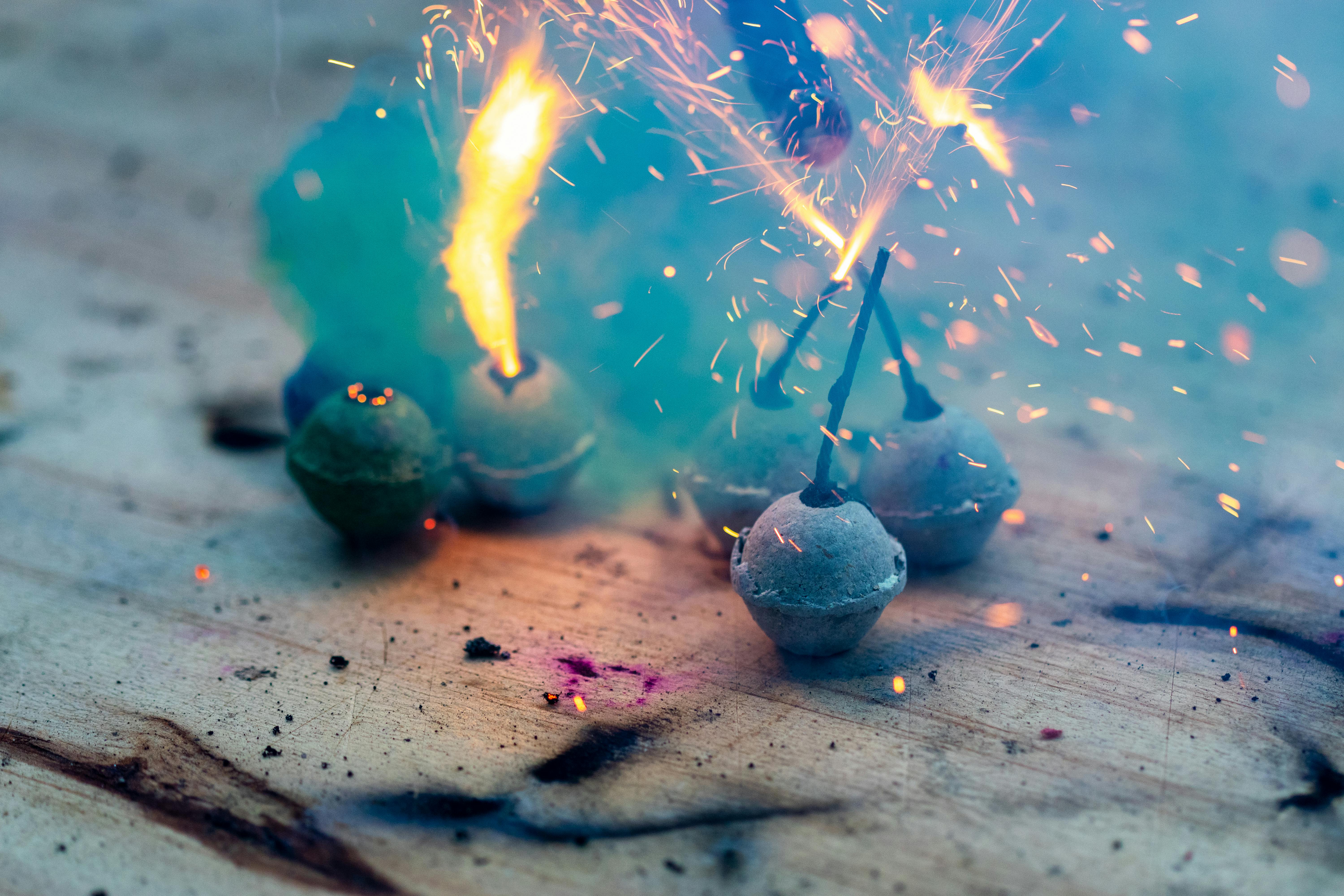 Festive fireworks exploding with vivid colors on a wooden surface, creating a sparkling display.