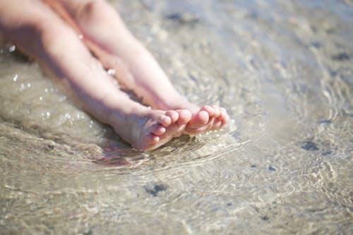 A Child's Feet on Shallow Water