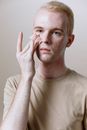 Man in Beige Crew Neck Shirt Covering His Face