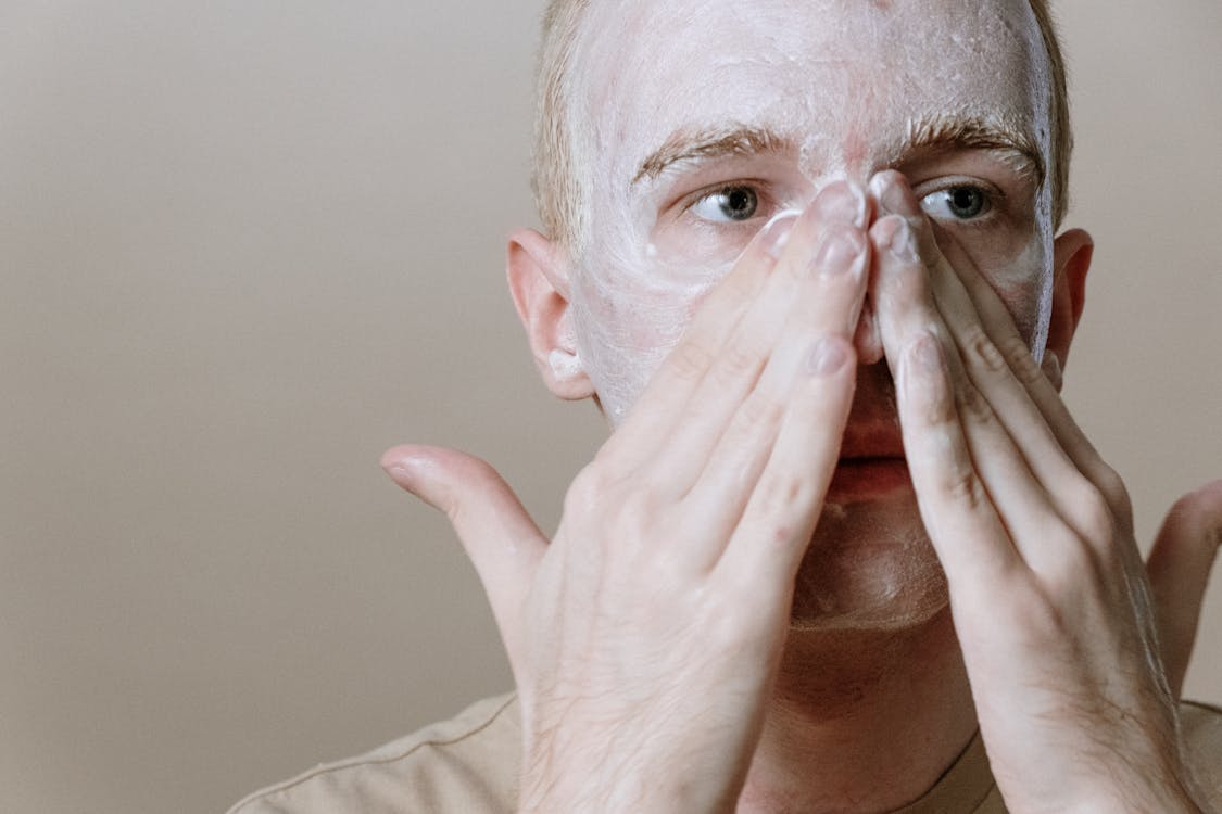 Man in White Shirt Covering Face With White Textile