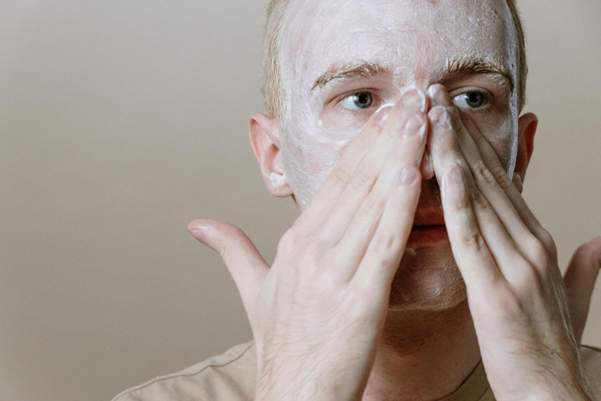 Man in White Shirt Covering Face With White Textile