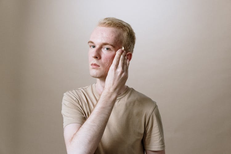 Man In Brown Crew Neck T-shirt Covering His Face