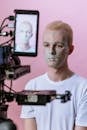 Man in White Crew Neck Shirt Holding Black and Gray Camera