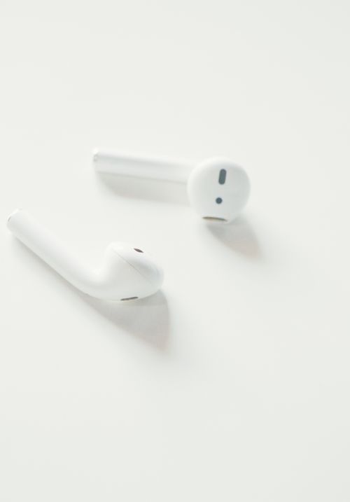Free A minimalist close-up image of white wireless earbuds on a white background. Stock Photo