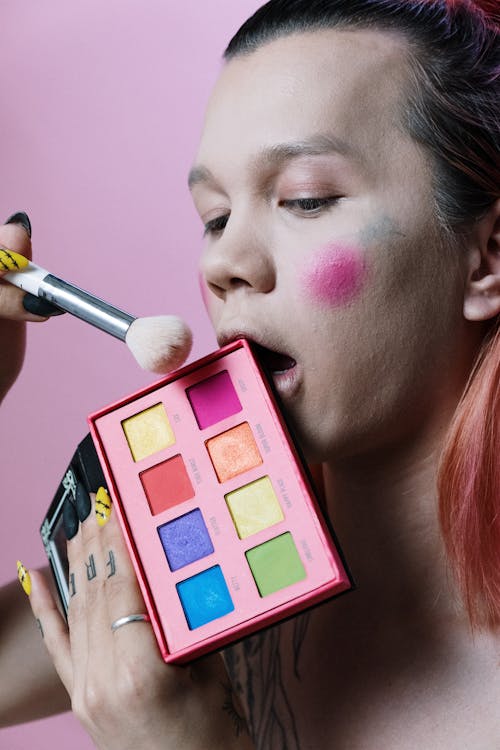 Woman With Pink Lipstick Holding Pink Eyeshadow Palette