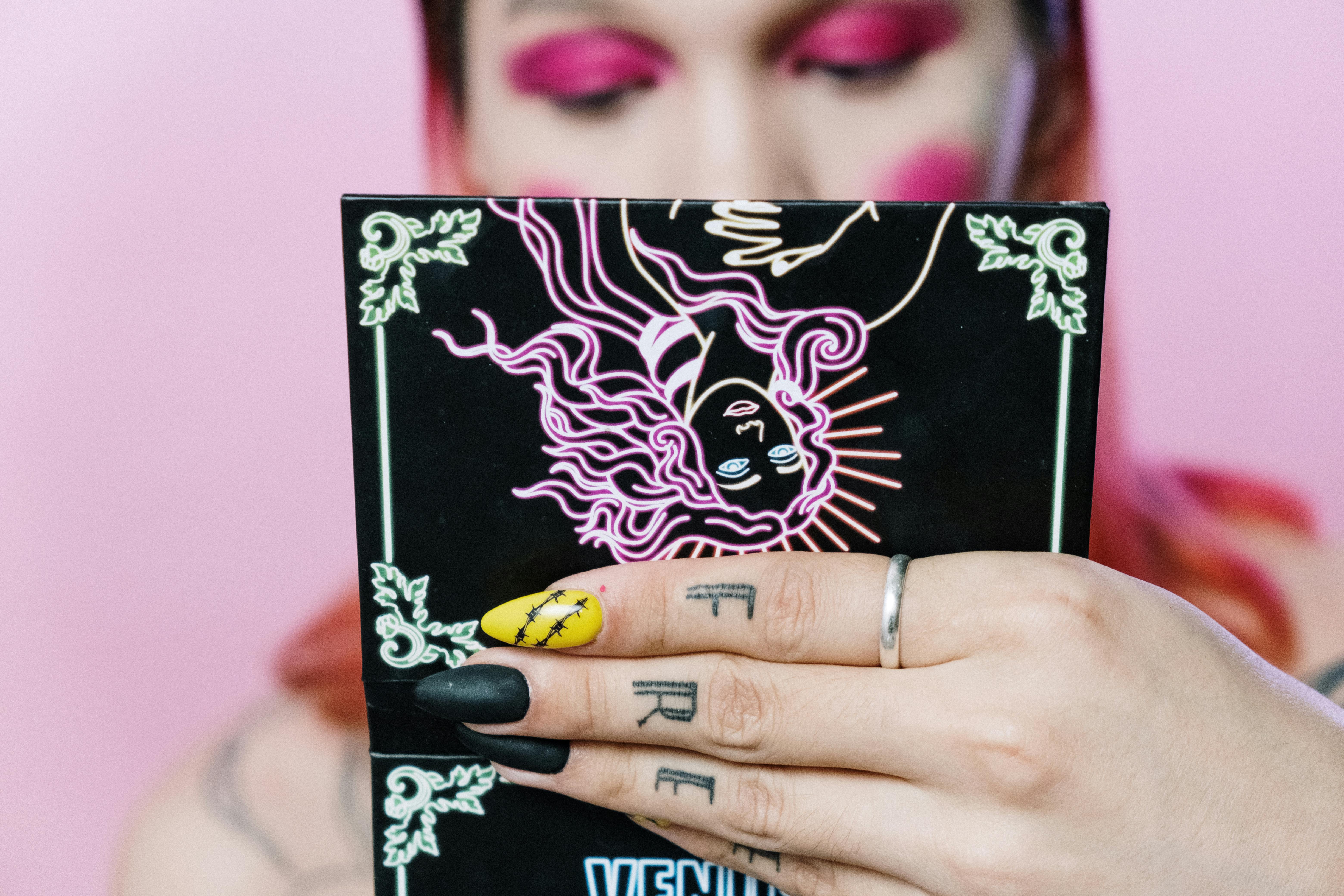 person wearing silver ring holding black and white book