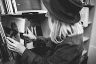 一位女士在经典的黑白背景下翻看黑胶唱片