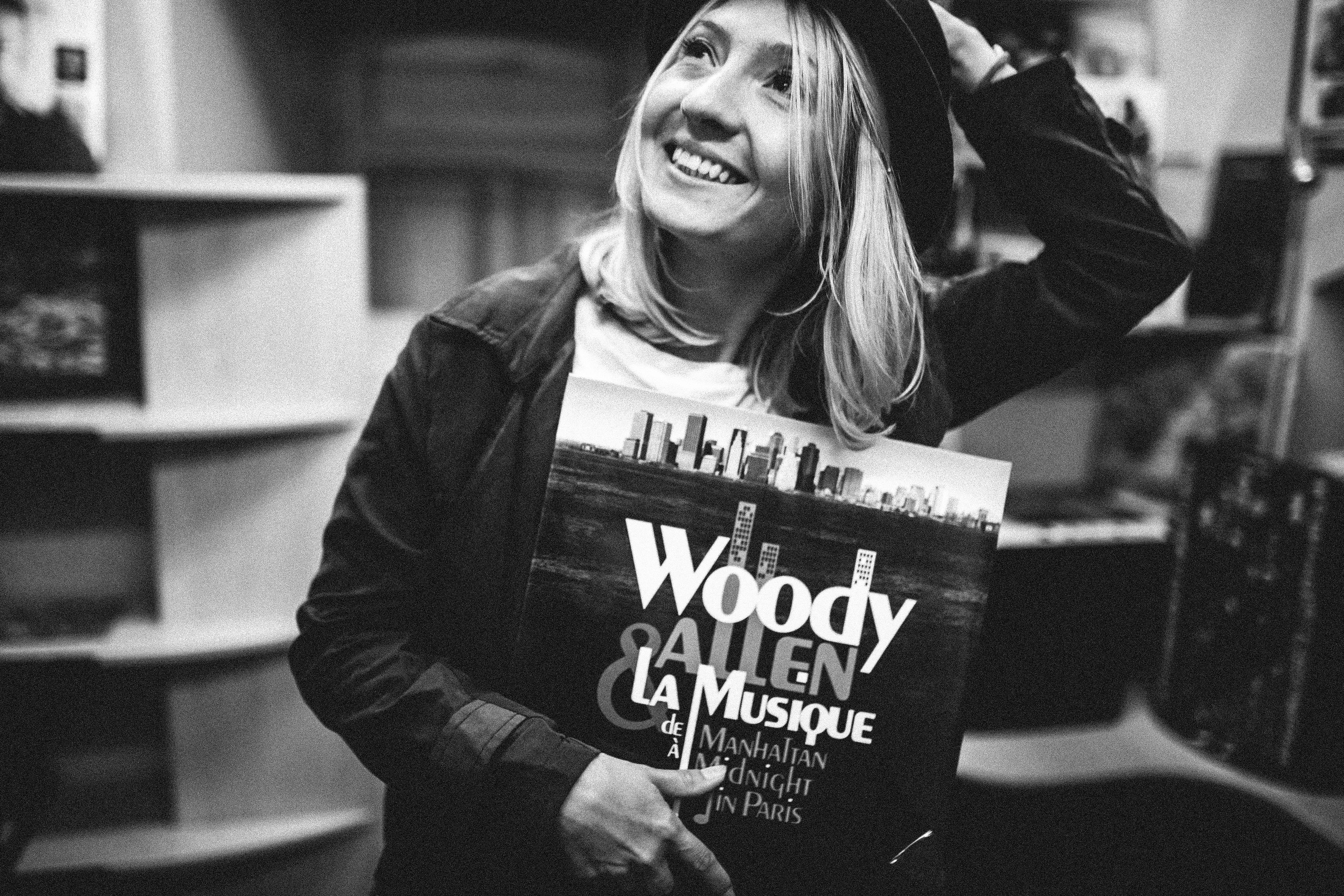 woman wearing a coat holding a music album