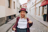 Woman in White Shirt and Red Coat Smiling With Tonge Out