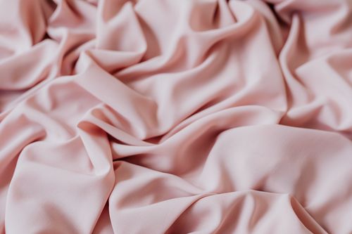 Free Smooth pink fabric with gentle folds, offering a cozy and elegant texture ideal for textile design. Stock Photo