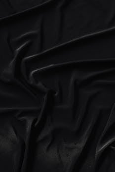 优雅的黑色面料特写，褶皱复杂，非常适合用作设计背景