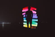 Anonymous man near neon lights on embankment