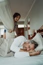 Man in White Long Sleeve Shirt Lying on Bed