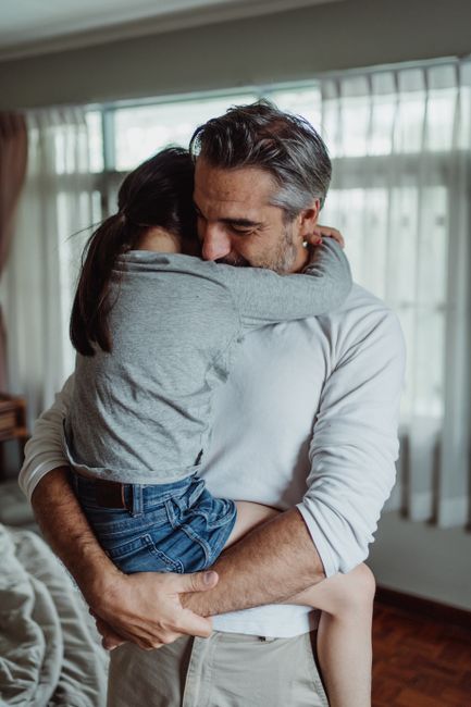 A loving moment between father and daughter, showcasing warmth and affection indoors.