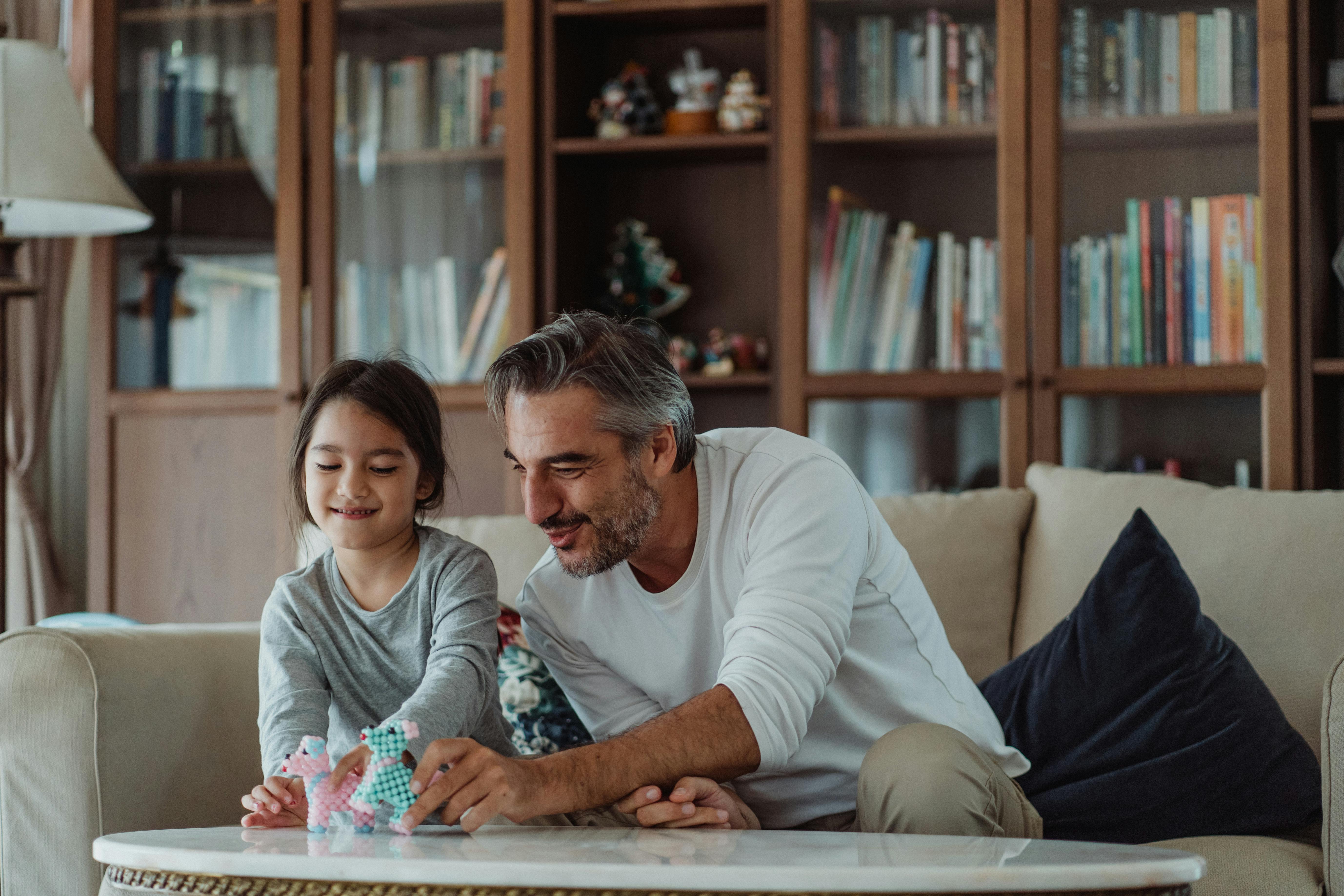 father and daughter playing with toys in living room