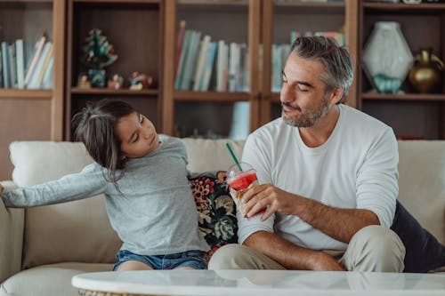 Father and Daughter Sitting on a Sofa