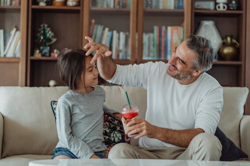 Man Sitting with his Daughter and Holding a Smoothie