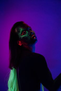这幅肖像引人注目，描绘了一个在黑光下涂着霓虹灯车身漆的人，展现出充满活力的色彩与创造力